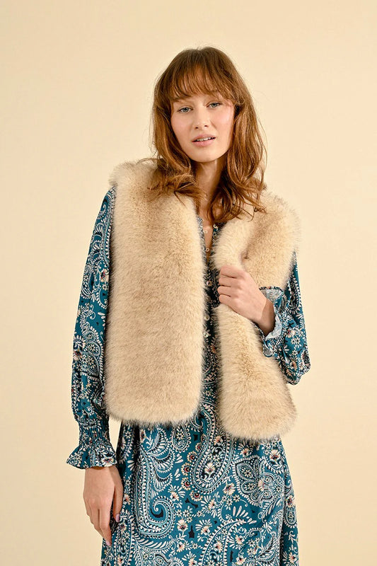 A person wearing a blue paisley-patterned dress and a fashion-forward Faux Fur Vest by Molly Bracken stands against a plain background.