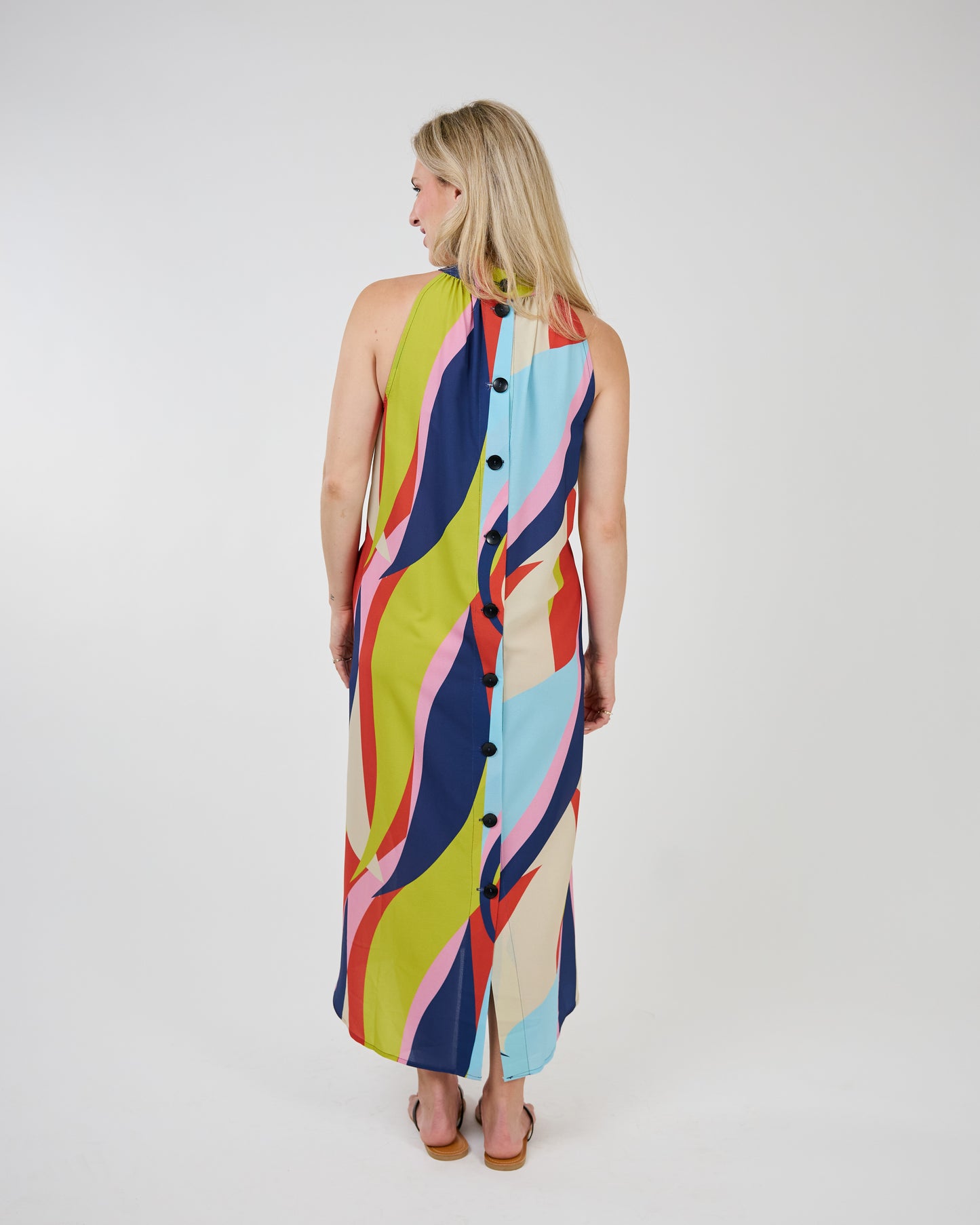 Woman in a colorful, eye-catching print Shannon Passero Long Waveprint Latanya Dress standing against a white backdrop.