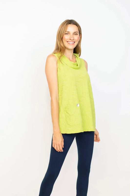 Woman posing in a green Habitat sleeveless stepped hem top and blue leggings against a white background.