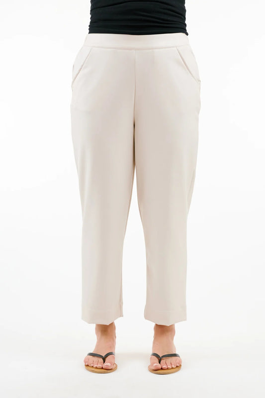 A person exudes understated style, wearing Shannon Passero's Windsor Crop Pant and comfortable sandals against a plain white background.