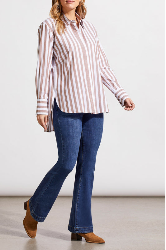 A person in a contemporary style, dressed in a striped Button Front Shirt with Pleats by Tribal, blue jeans, and brown boots, strides against a neutral background.