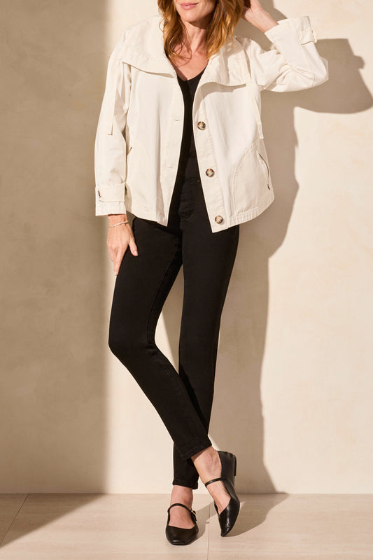 A woman models the Tribal's LONG SLEEVE BUTTON COAT in white, showcasing a cute style paired with a black top and pants against a plain backdrop.