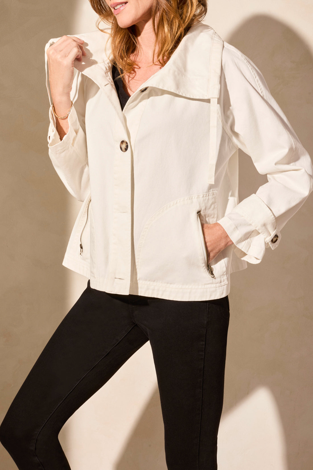 A woman models the Tribal's LONG SLEEVE BUTTON COAT in white, showcasing a cute style paired with a black top and pants against a plain backdrop.