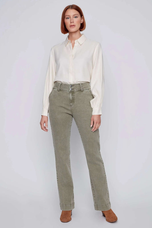 A person stands against a plain background wearing a white blouse, high waist khaki jeans by CoCo Y Club with a flattering fit, and brown boots.