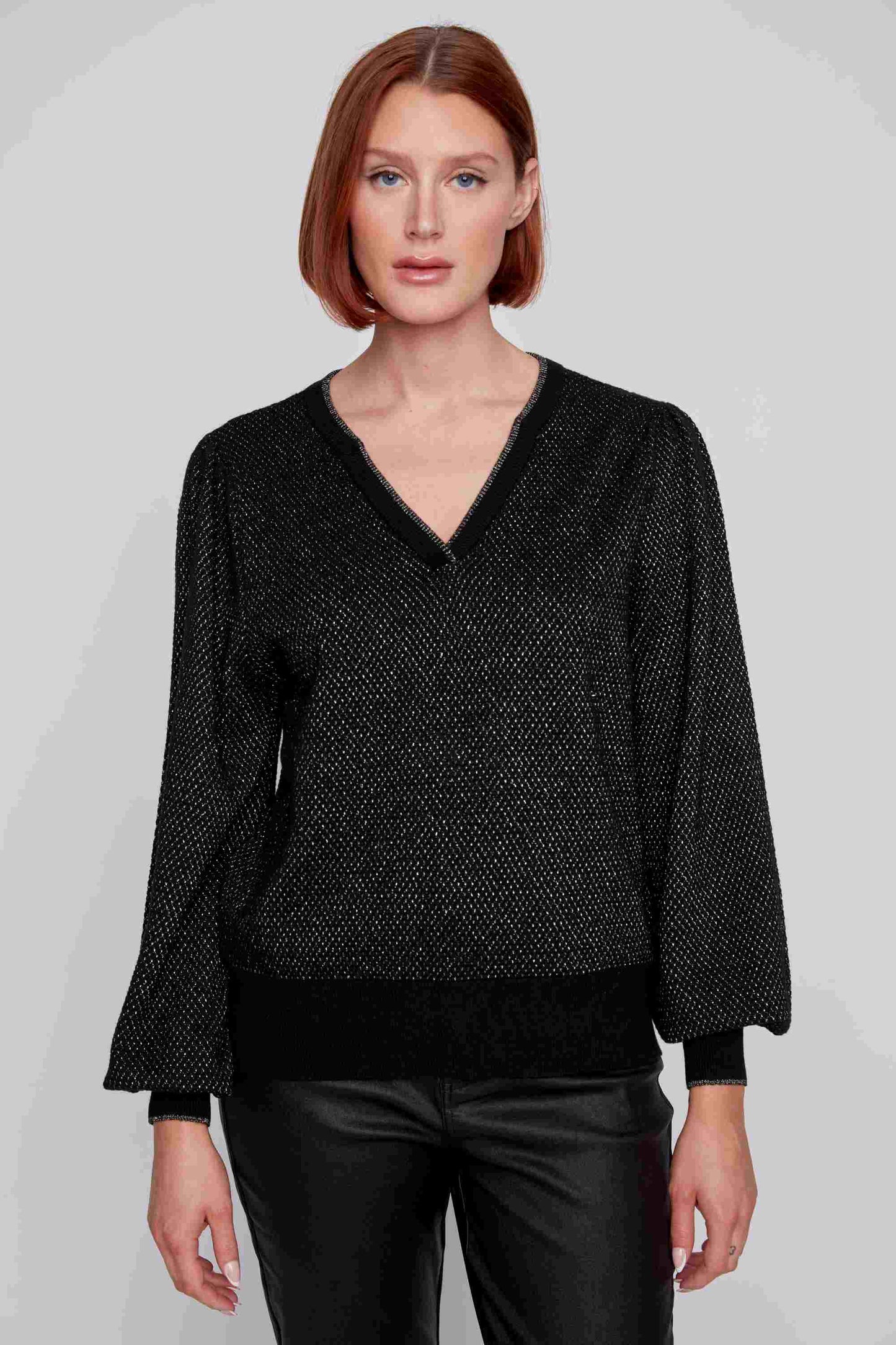 A person with straight, short red hair wearing a trendy V Neck Puff Sleeve Top by CoCo Y Club and matching black pants stands against a plain gray backdrop.