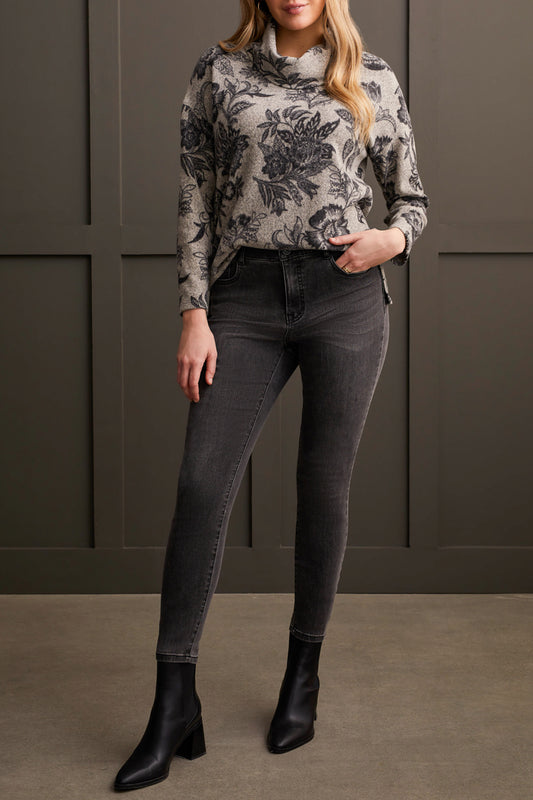 A person wearing the Tribal Long Sleeve Cowl Neck Top paired with dark jeans and black ankle boots stands in front of a dark paneled wall.