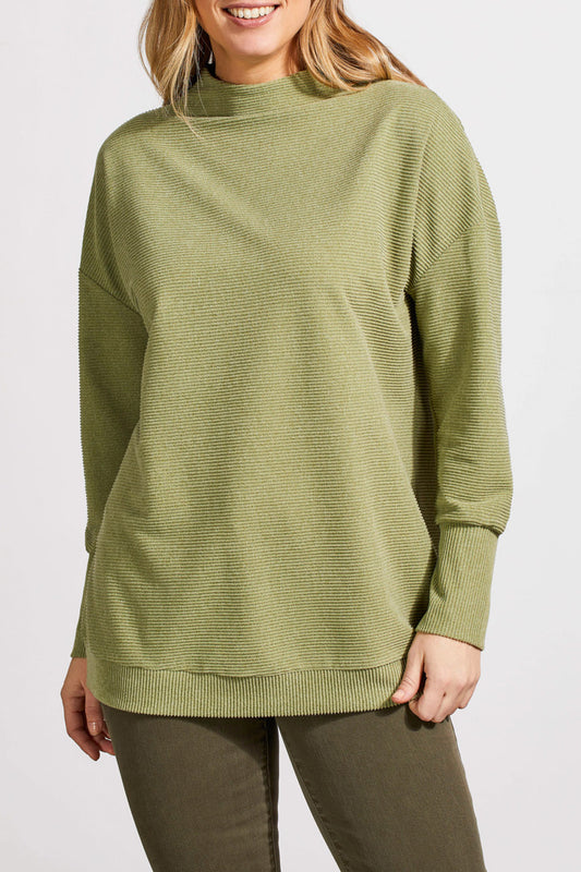 A person wearing a light green, long-sleeved knit sweater and green pants stands against a plain white background. The comfortable outfit includes the Funnel Neck Tunic by Tribal, which adds an extra touch of style.