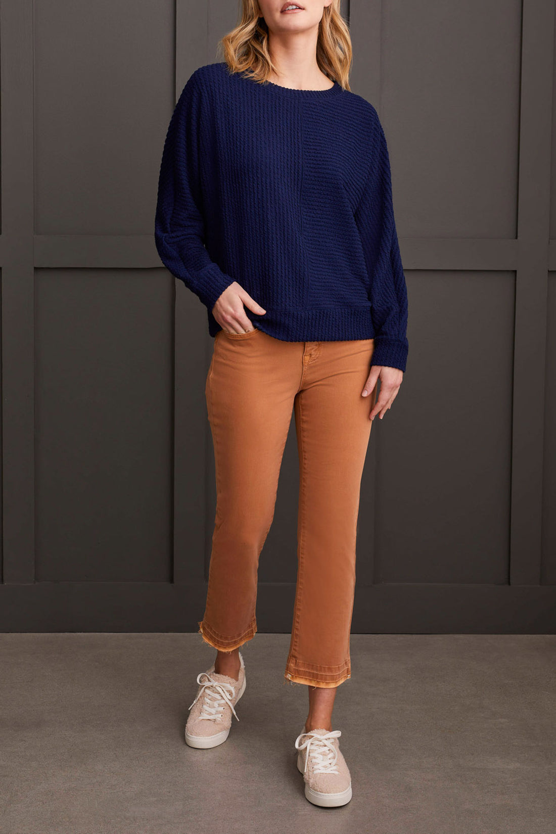 A person wearing a Tribal Crew Neck Dolman Sleeve Top in textured navy blue is shown from the shoulders to the waist against a dark background, showcasing ultimate comfort and style.