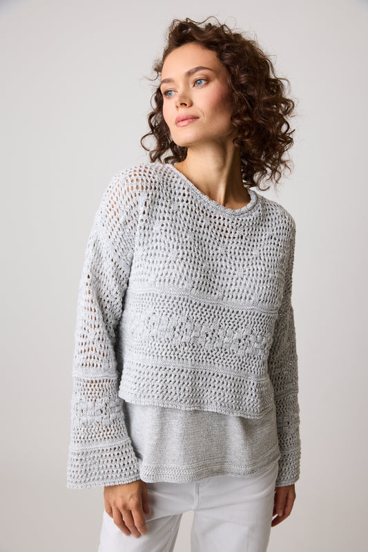 A woman with curly hair wears the Parkhurst Shorty Eco Shimmer Top in textured gray, looking to the side against a plain backdrop.