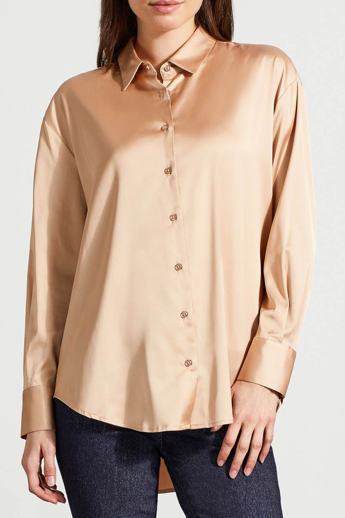 A person dressed in a cozy fall top, specifically the beige Drop Shoulder Shirt by Tribal with silk fabric, pairs it effortlessly with dark jeans against a light background.