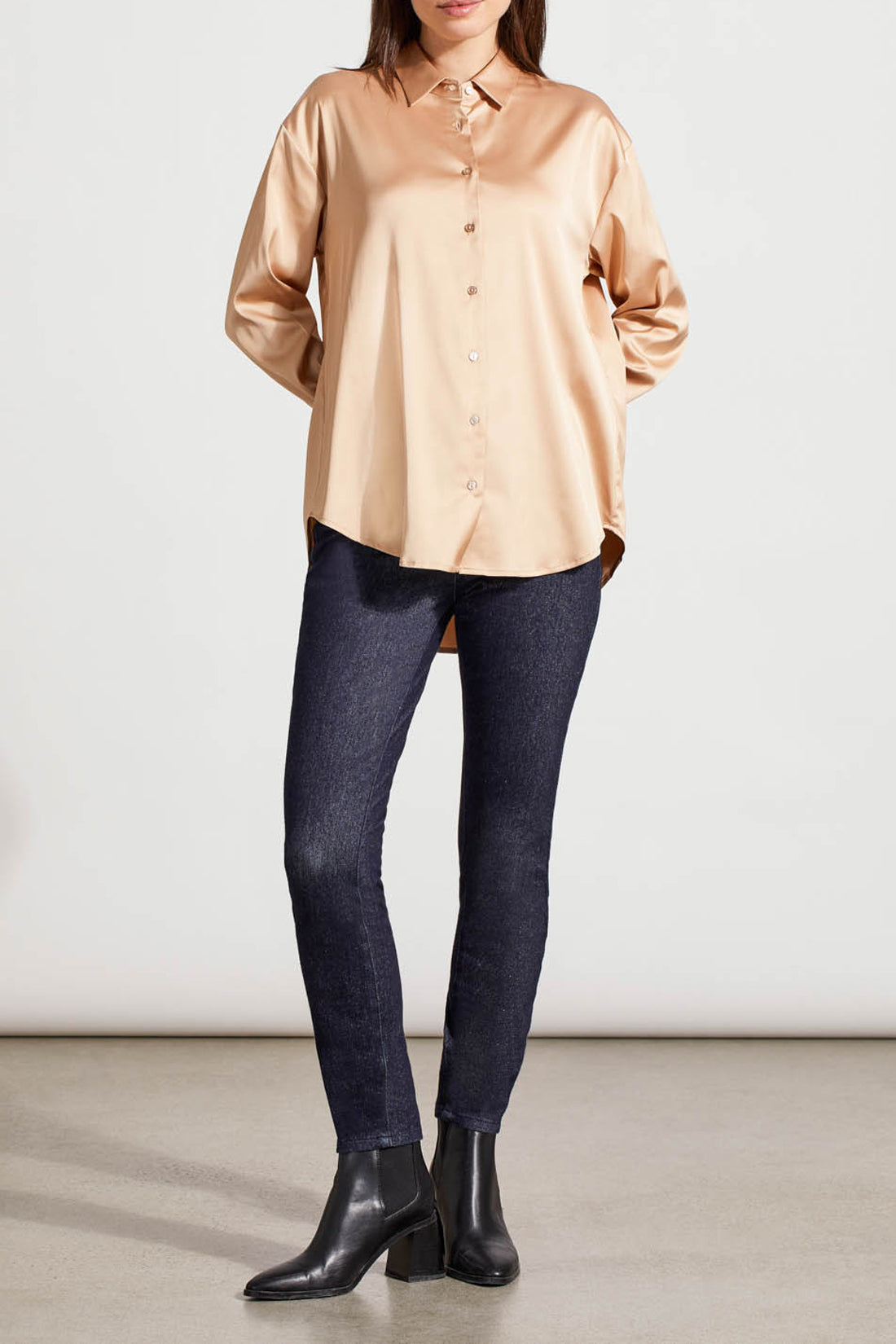 A person dressed in a cozy fall top, specifically the beige Drop Shoulder Shirt by Tribal with silk fabric, pairs it effortlessly with dark jeans against a light background.