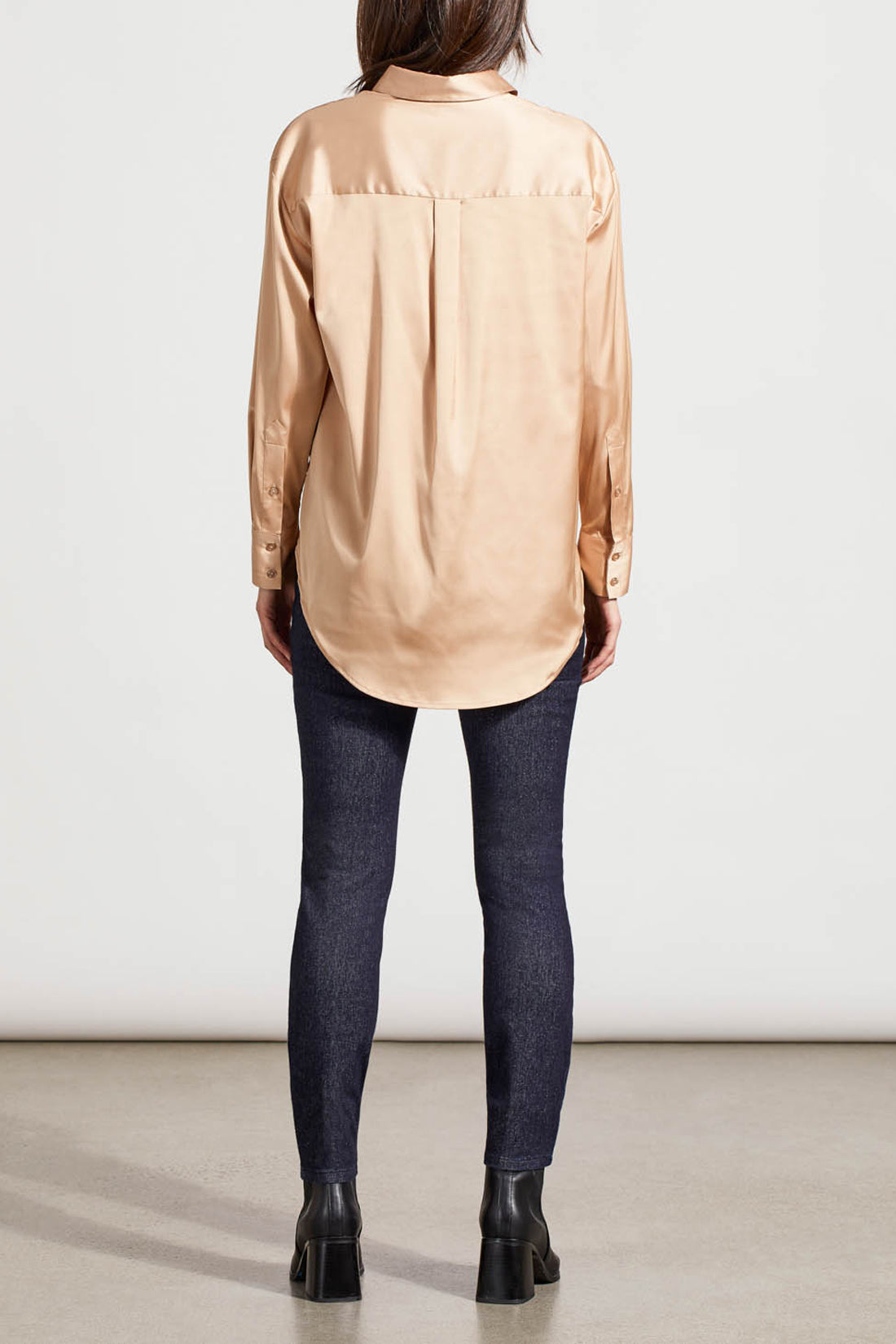 A person dressed in a cozy fall top, specifically the beige Drop Shoulder Shirt by Tribal with silk fabric, pairs it effortlessly with dark jeans against a light background.