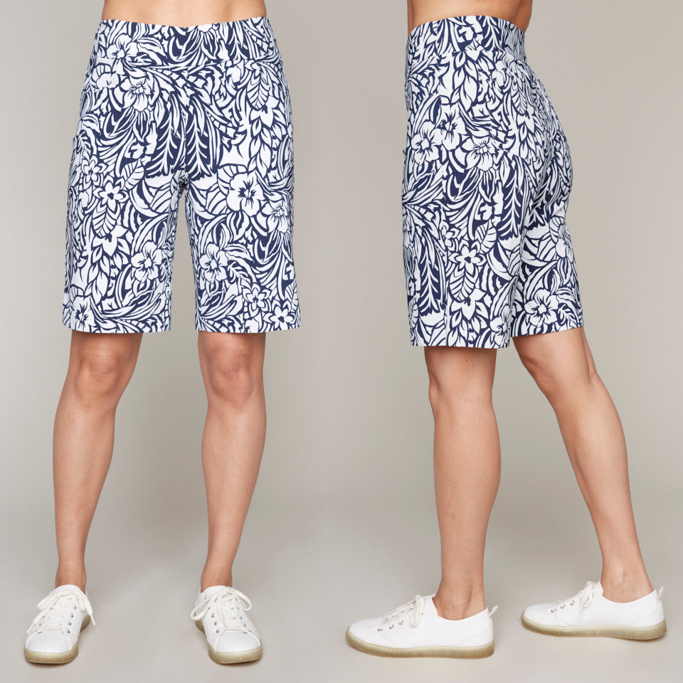 Front and side profiles of a model wearing Carre Noir's Blue Floral Print Bermuda Shorts and white sneakers, set against a gray background.