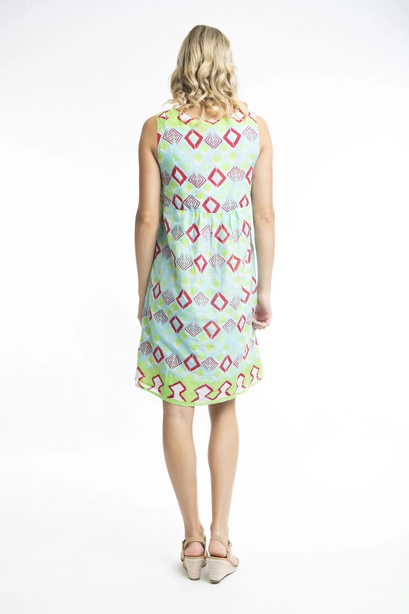 A woman smiling while posing in a Zio Turq Dress Reversible Sleeveless by Orientique on a white background.