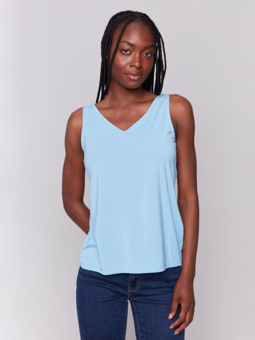 A person wearing a Charlie B Reversible Bamboo Viscose Cami and dark blue jeans stands against a plain gray background.