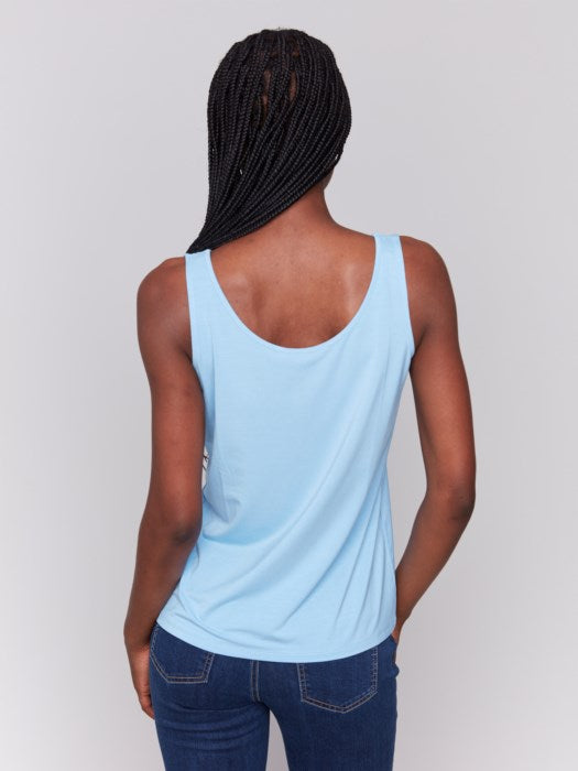 A person wearing a Charlie B Reversible Bamboo Viscose Cami and dark blue jeans stands against a plain gray background.