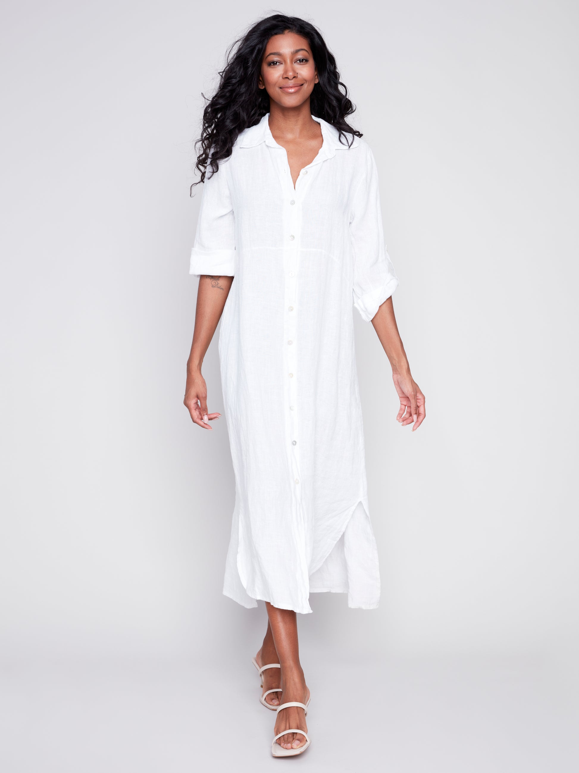 The model is wearing a white Charlie B duster with rolled-up sleeves and denim shorts.