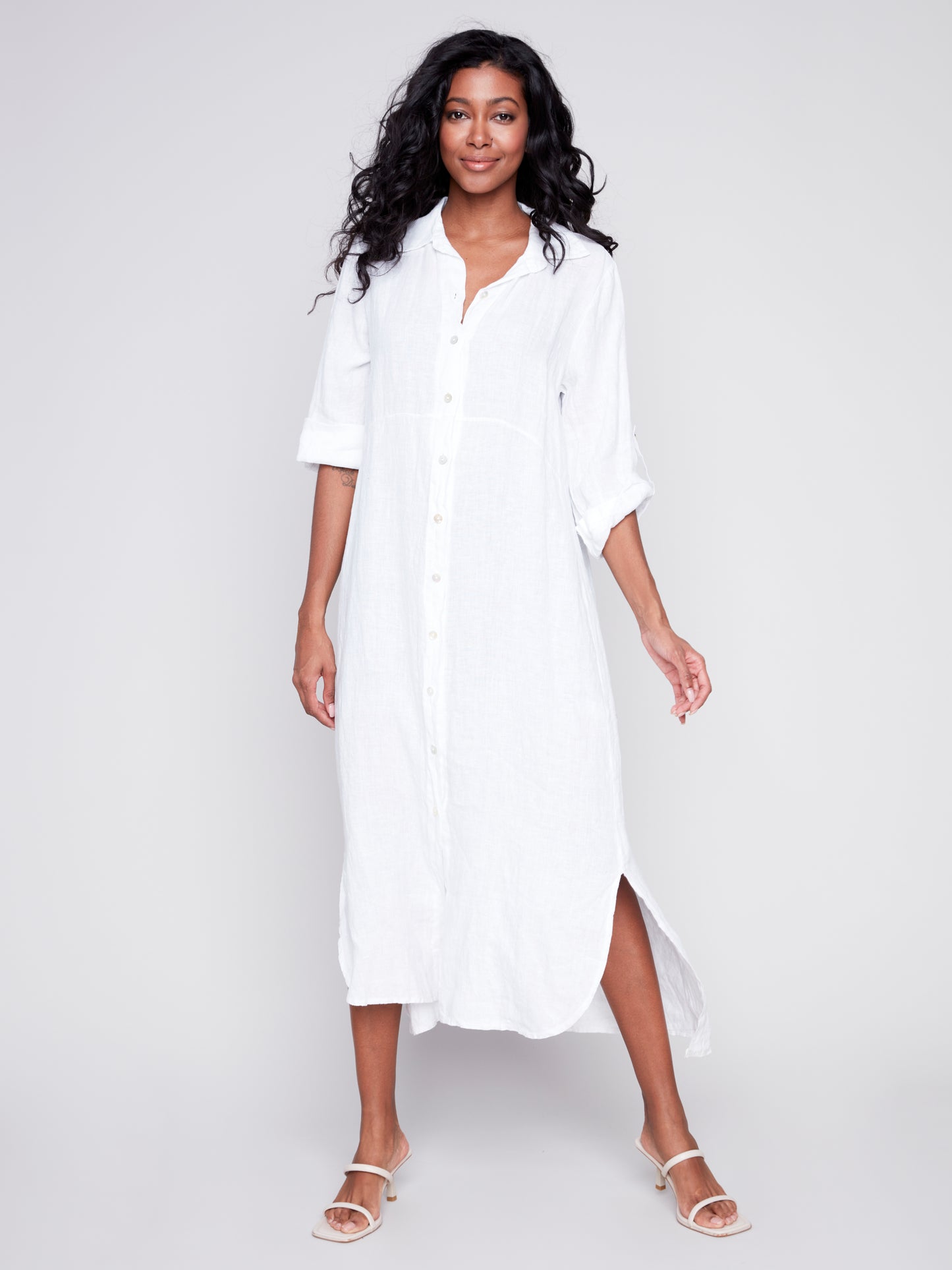 The model is wearing a white Charlie B duster with rolled-up sleeves and denim shorts.