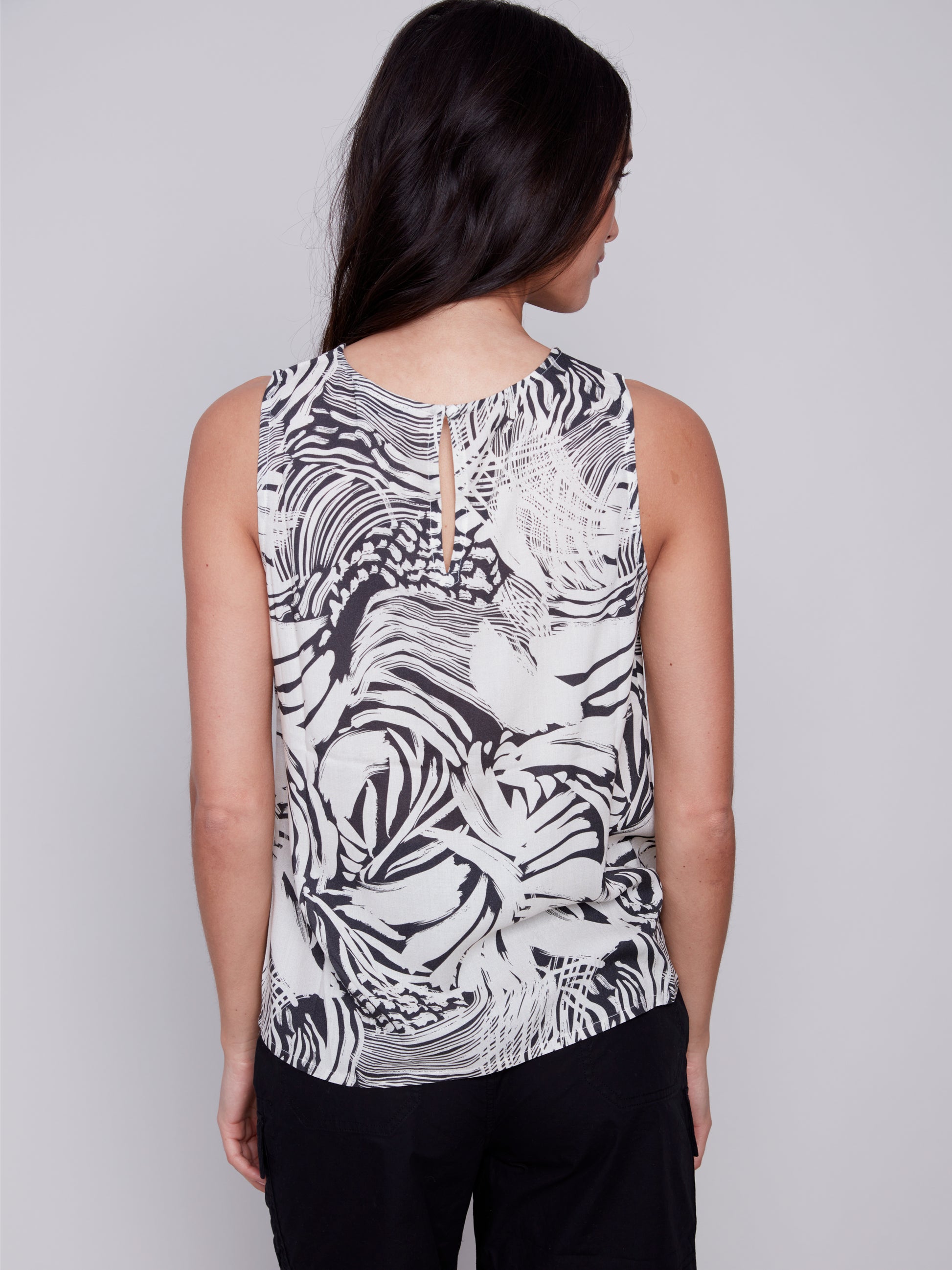 A woman in trendy black and white shorts and a Classic Sleeveless Top by Charlie B.