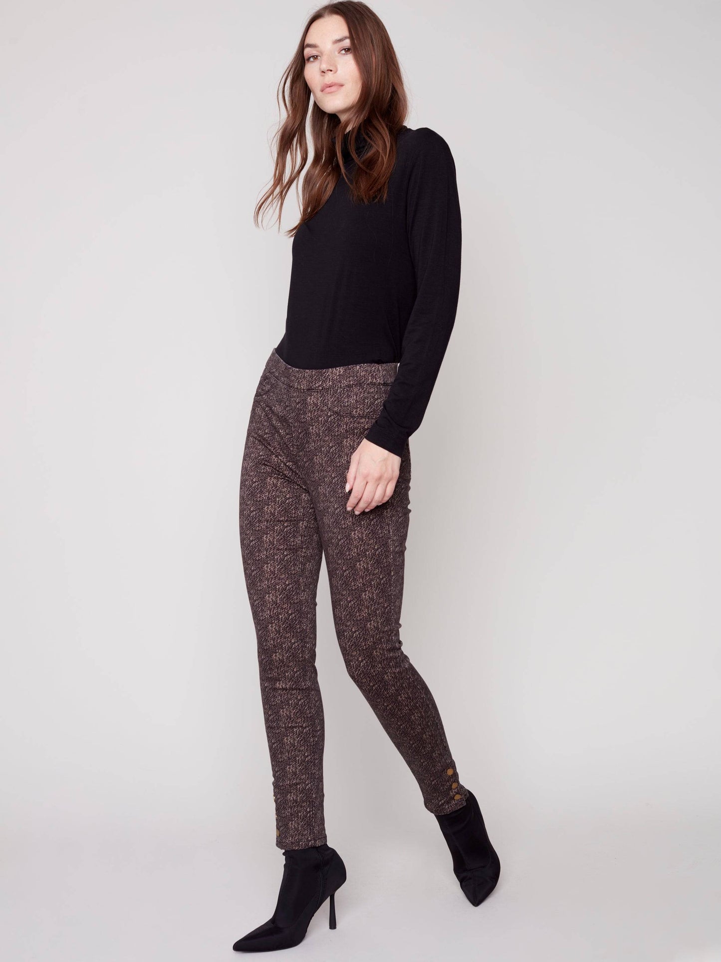 The model is wearing a black turtleneck and brown Charlie B Printed Twill Pull On Pant.