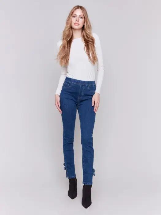 A person wearing Charlie B's Pull On Side Rose Hem Pant with a sleek silhouette and black ankle boots, standing against a plain background.