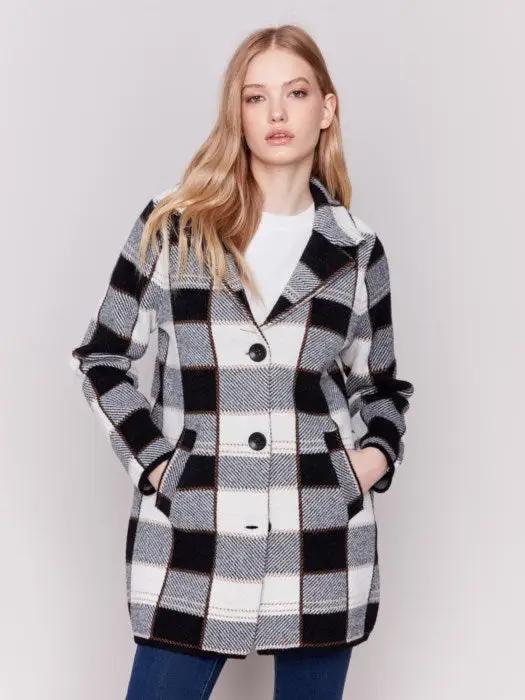 A woman with long hair, standing against a plain background and showcasing her winter wardrobe, is wearing the Charlie B Knit Plaid Coat along with jeans.