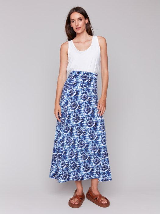 A model in a Charlie B Printed Convertible Skirt/Dress with removable spaghetti straps, featuring a blue and white tie-dye design, stands against a plain background.