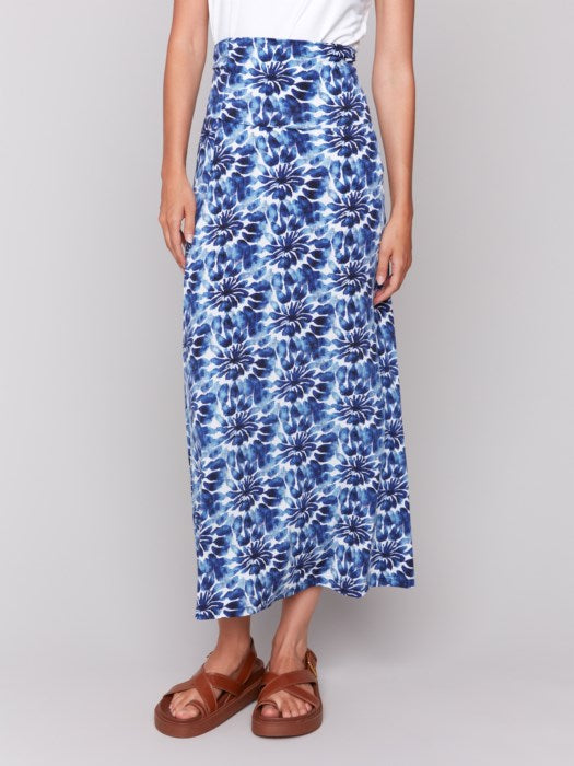 A model in a Charlie B Printed Convertible Skirt/Dress with removable spaghetti straps, featuring a blue and white tie-dye design, stands against a plain background.