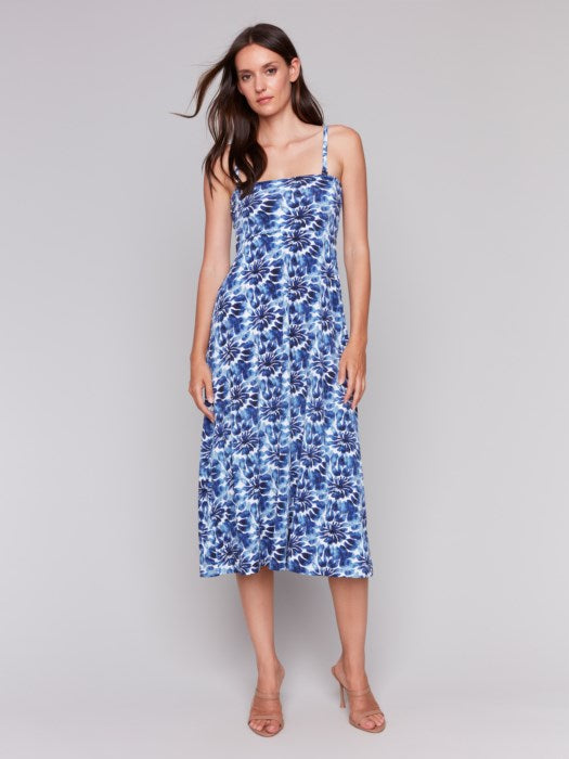 A model in a Charlie B Printed Convertible Skirt/Dress with removable spaghetti straps, featuring a blue and white tie-dye design, stands against a plain background.