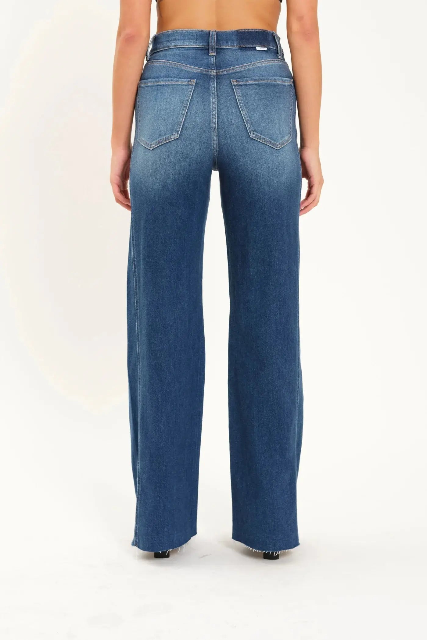 A person wearing Daze's Far Out With Front Seam High Rise wide-leg blue jeans stands facing forward against a plain background.