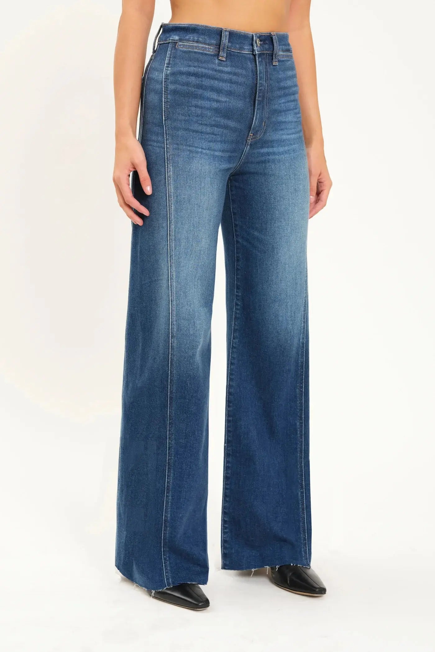 A person wearing Daze's Far Out With Front Seam High Rise wide-leg blue jeans stands facing forward against a plain background.