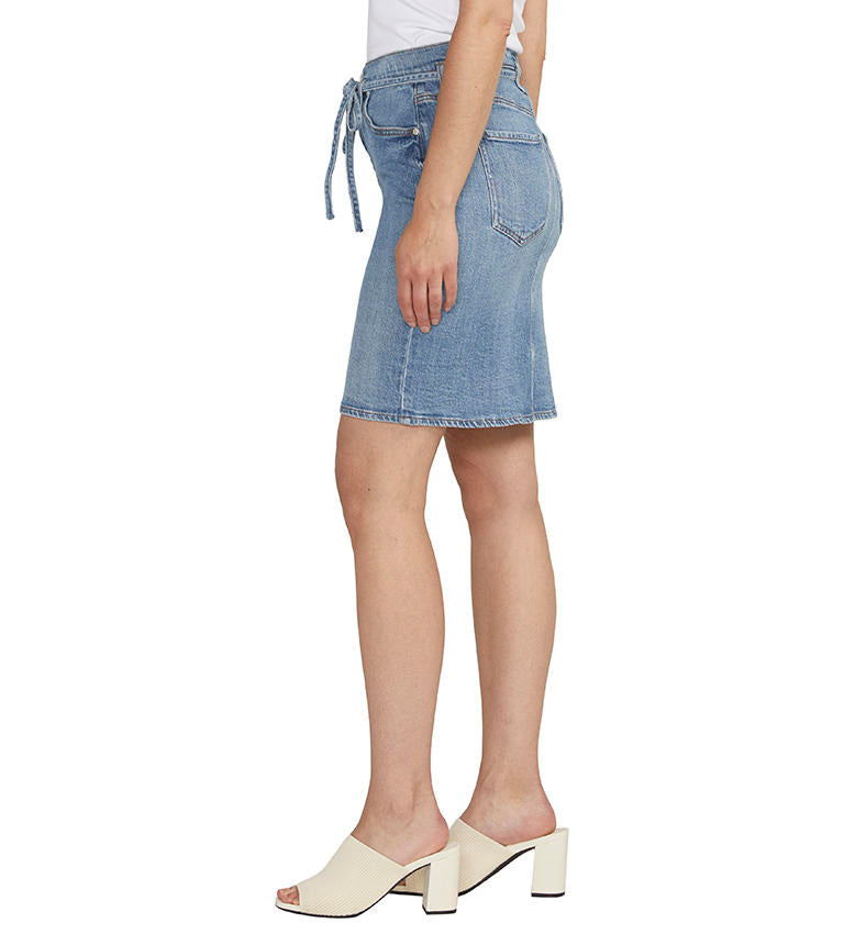 Woman wearing a Luna Knee Length Denim Skirt from Jag and white mules.