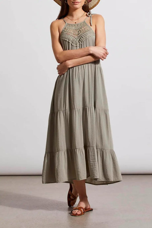 A woman standing in a neutral pose wearing a Tribal lined sleeveless dress with adjustable straps and brown sandals.