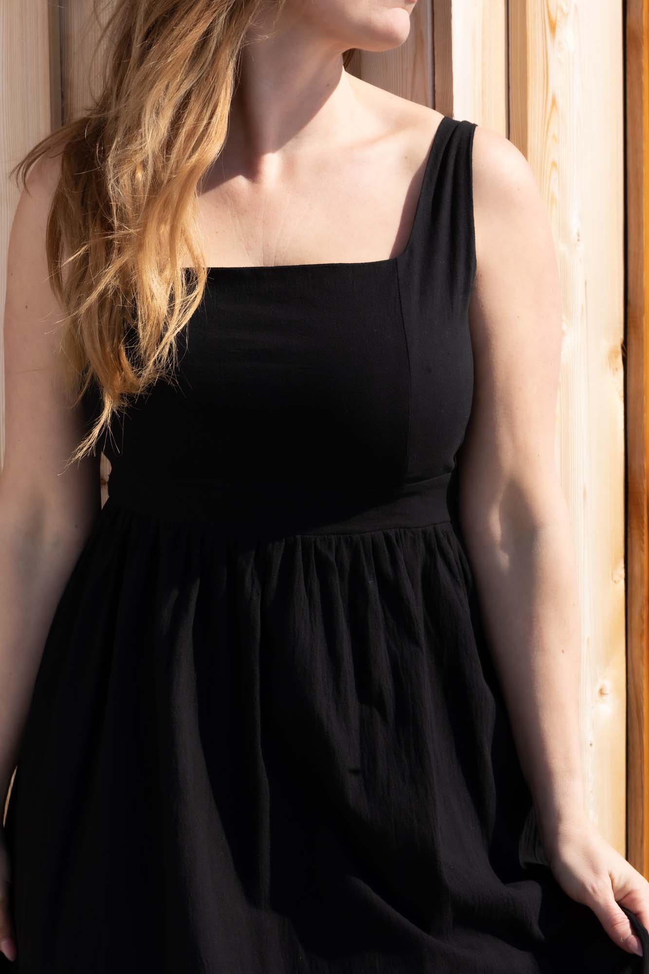 A woman wearing a Square Collar Sleeveless Solid A Line Midi Dress in Black color from Don't Be Chy Boutique.