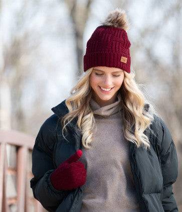 A woman wearing a Britt's Knits Classic Pom Hat in cold weather.