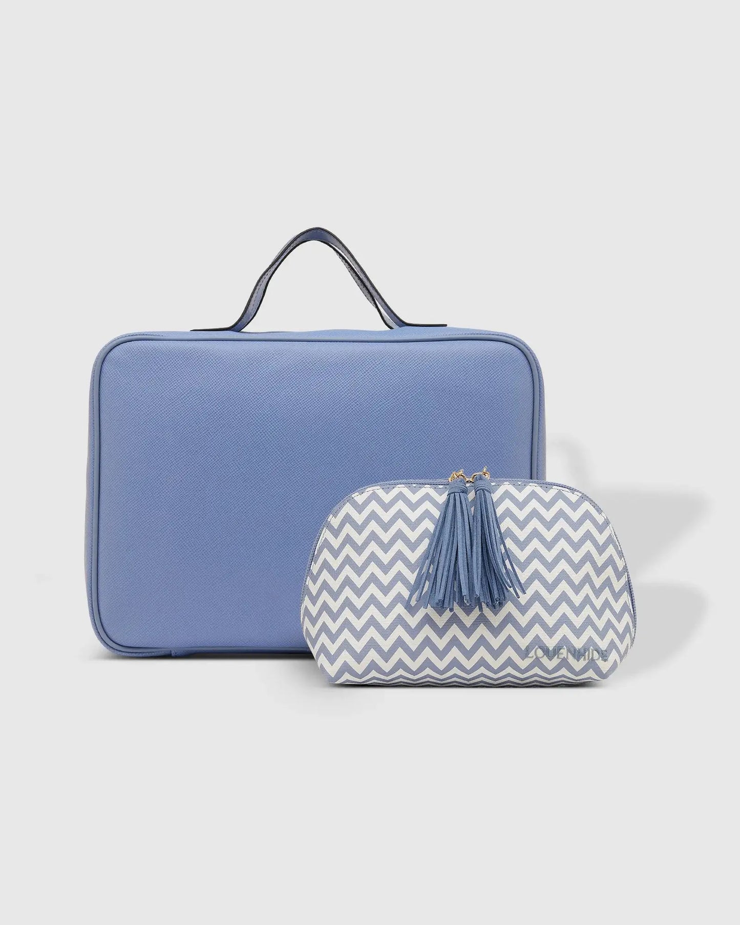 The Emma & Baby Audrey Cosmetic Set from Louenhide includes a blue rectangular travel cosmetic case with a black handle, paired with a smaller white and blue chevron-patterned pouch adorned with a pair of tassels. This set provides your largest toiletry case solution on the go.