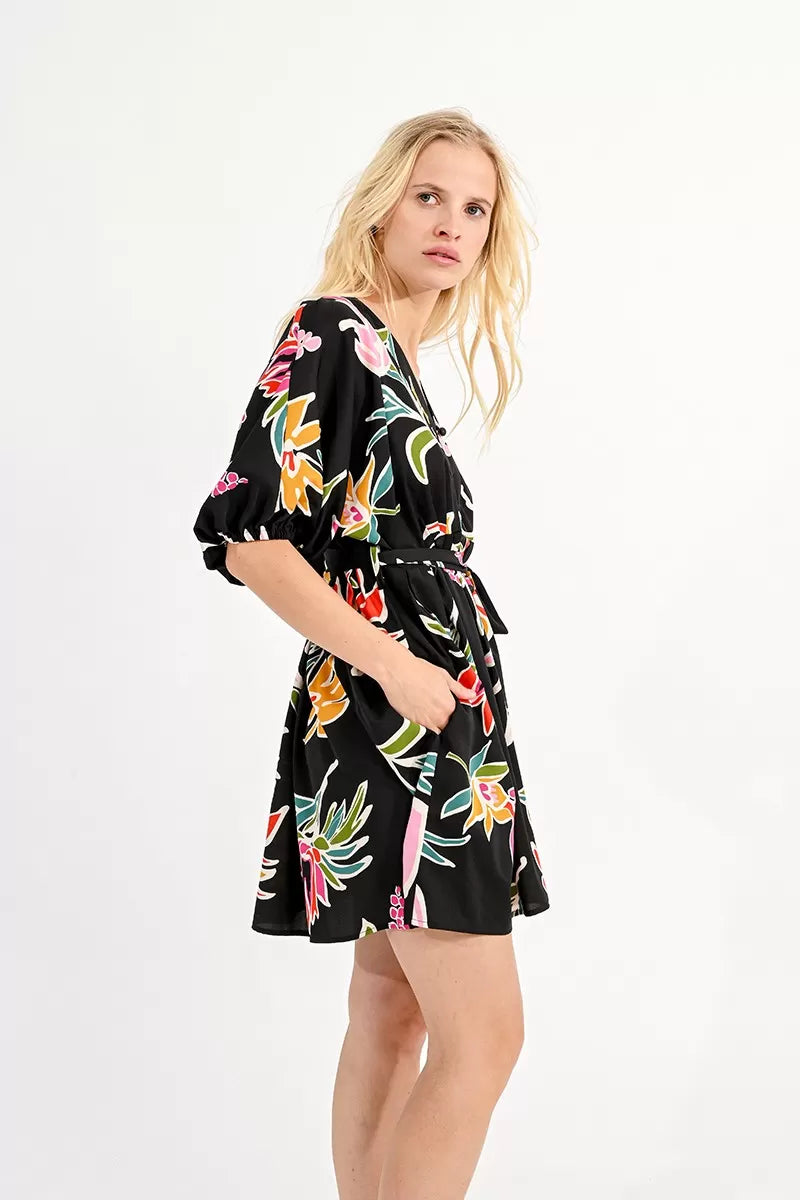 Woman wearing a Molly Bracken belted mini shirt dress with a floral print, ideal for a summer wardrobe.