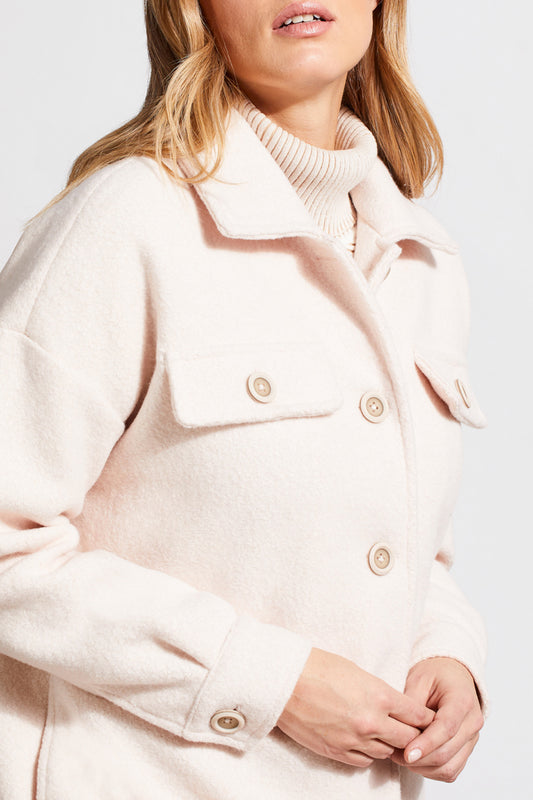 An individual with light hair is wearing a pale cream Stretch Boiled Wool Jacket by Tribal, featuring double-breasted button details. They are also dressed in a ribbed turtleneck sweater and are positioned against a plain background.