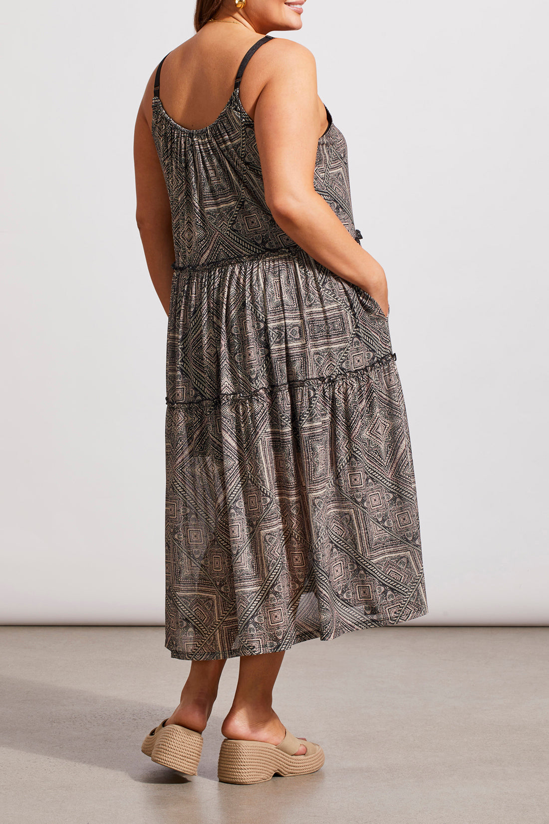 A woman in a Tribal Two Way Strappy Dress and white heels, posing in a studio setting.