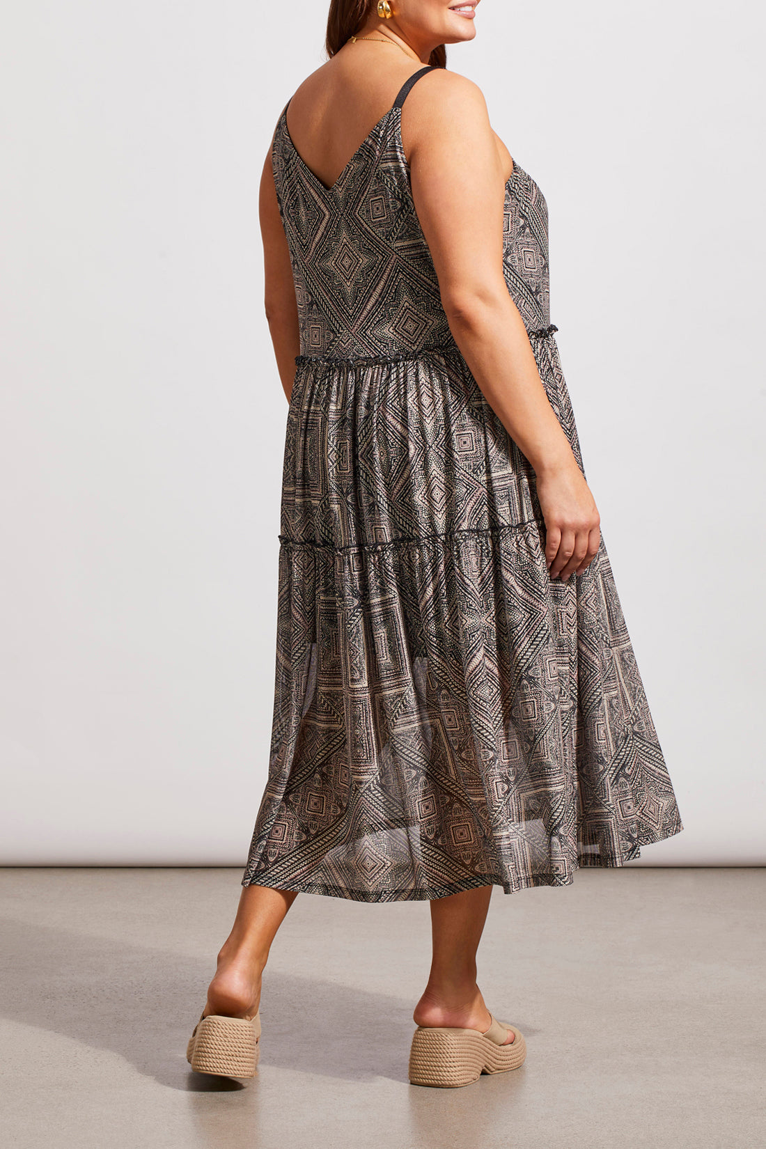 A woman in a Tribal Two Way Strappy Dress and white heels, posing in a studio setting.