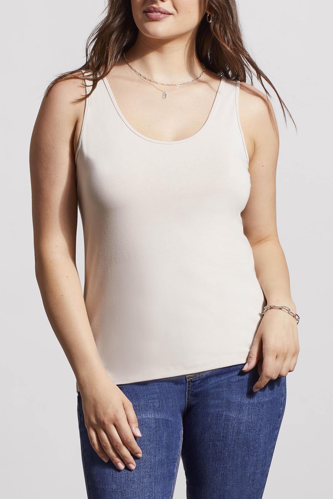 A woman in a cream Tribal Two Way Camisole and blue jeans, standing with one hand partially in her pocket.